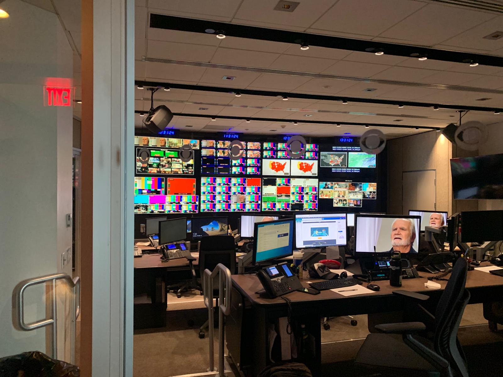 Broadcast operator workstations surrounded by monitoring screens at CBS Studios.
